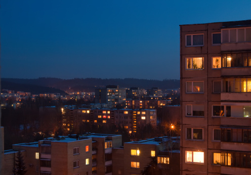 view of residential houses with lit windows, in winter night