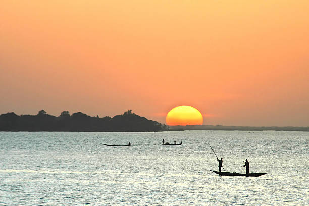 pescadores africanos, em canoas ao pôr do sol - niger river imagens e fotografias de stock
