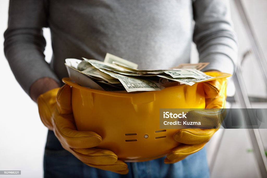 profit financial concept with dollars and yellow hardhat, selective focus on nearest part Construction Industry Stock Photo