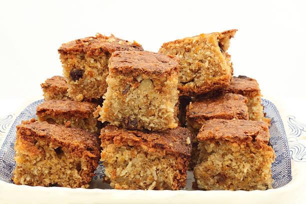 Tea time cake Stack of carrot cake squares on a blue and white plate with a white background carrot cake stock pictures, royalty-free photos & images