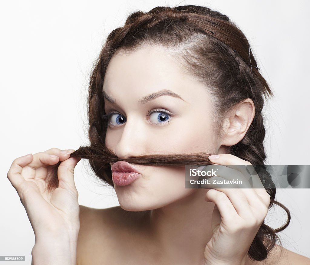 Young girl playing with her hair hairstyle portrait of beautiful brunette girl with creative hairdo putting braid's tail end like moustache 20-24 Years Stock Photo