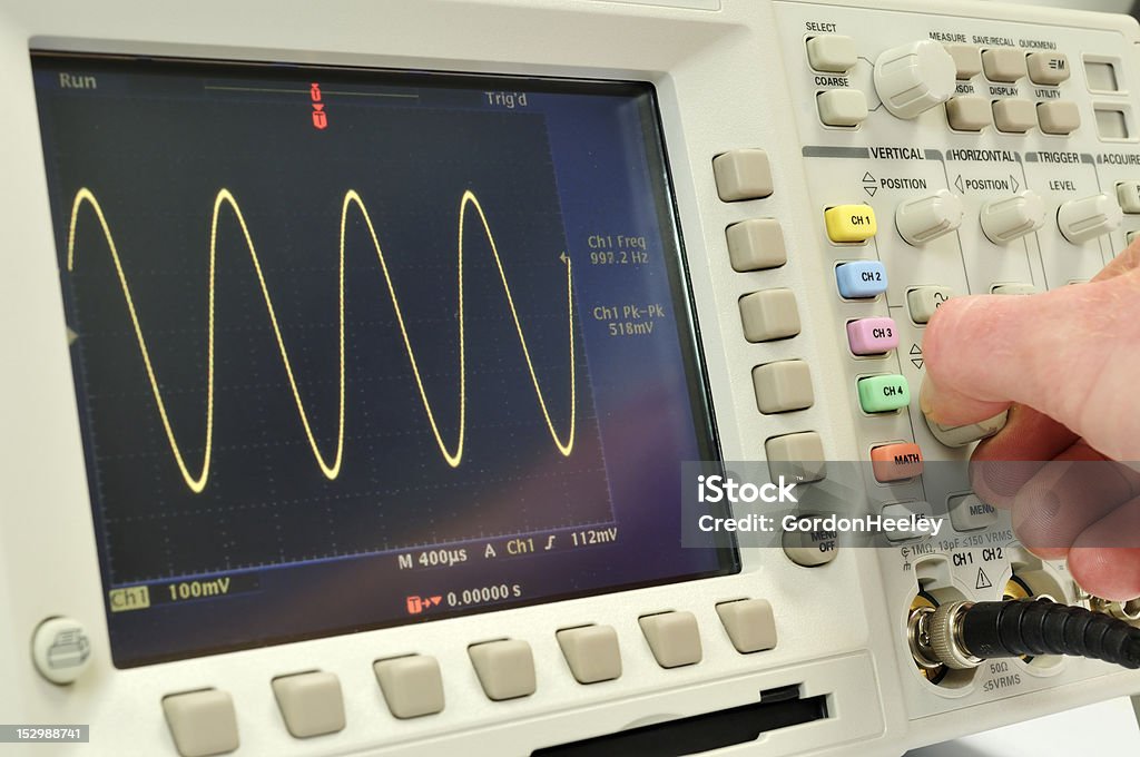 Oscilloscope Oscilloscope displaying a sine wave being adjusted by the enginer Oscilloscope Stock Photo