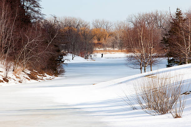 nature photographer dedicated, solitary distant photographer in silhouette on an ice covered pond after a big snowfall highland park michigan stock pictures, royalty-free photos & images