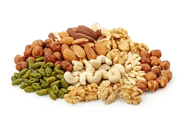 Photo of Pile of assorted nuts on white background