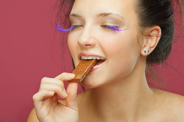 istock young woman bites off from chocolate 152993105