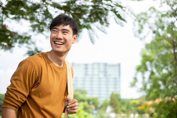 istock Young handsome man with a backpack is walking alone the park 1529945386