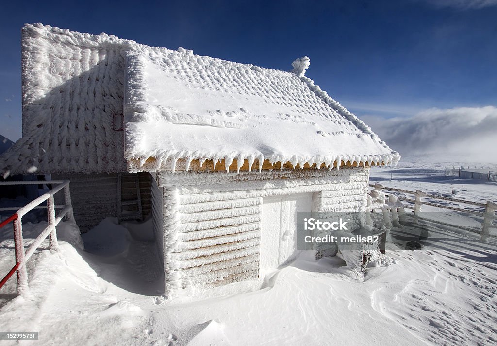 cottage in legno coperto con neve nelle montagne - Foto stock royalty-free di Albero