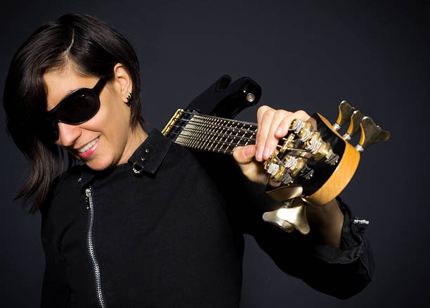 A young woman is playing her guitar outside.