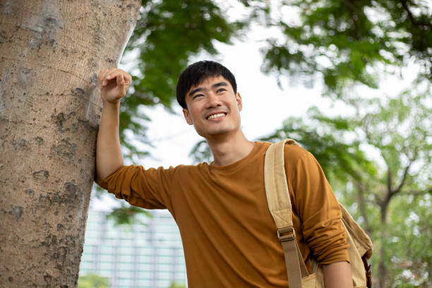 istock Young handsome man with a backpack is walking alone the park 1529963341