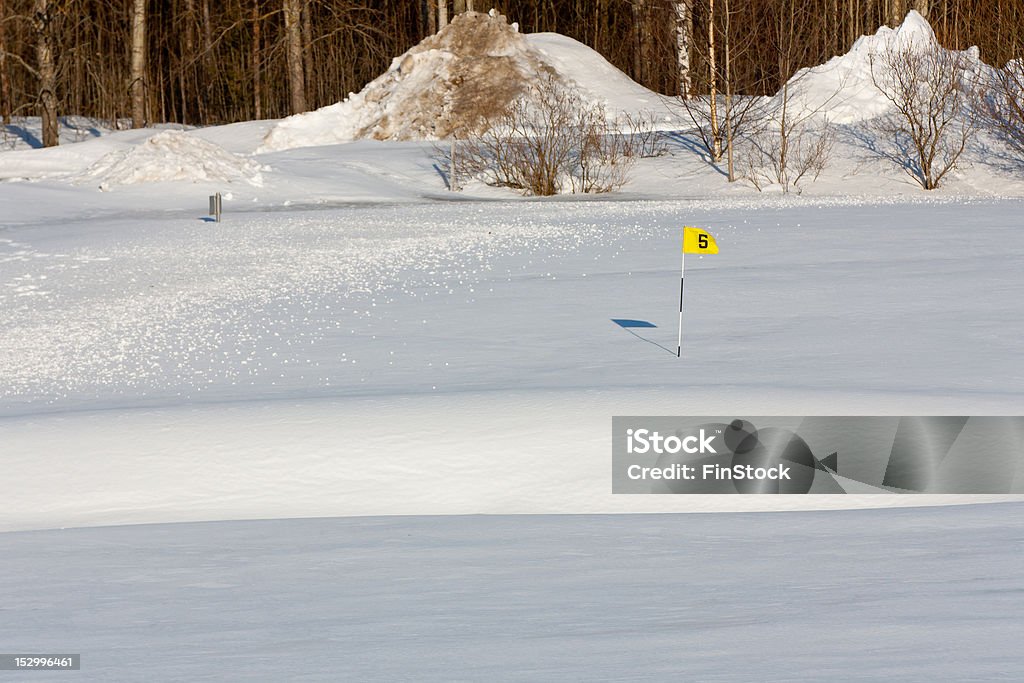 Waiting for the next season A golf green covered in snow with the shape of a sand bunker visible in front. Golf Stock Photo