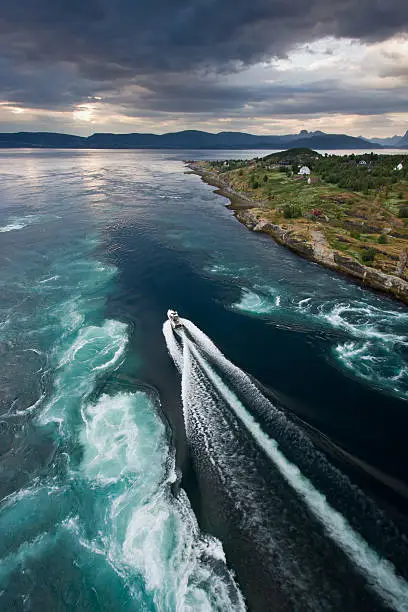 A speedboat is making its way towards the ocean at Saltstraumen, Norway. Saltstraumen is a sound with a strong tidal current located in Nordland 30 km east of the city of BodÃ¸, Norway.