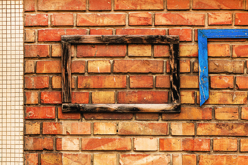 Old wooden frame on brick wall as mockup copy space or abstract background