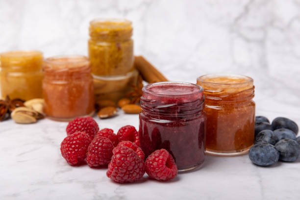 jar of honey. fruit honey with raspberries, blueberries, almonds and pistachios. jams for health and beauty. honey cream. organic product of a vegetarian diet. copy space.copy space. - marmelada imagens e fotografias de stock