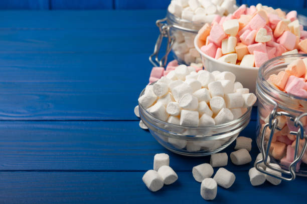istock Many different marshmallows in bowls and jars on  textured wood. White and fruit marshmallow. Sweets and snacks for a snack. Chewing candies close-up. Copy space. Place for text. 1529990418