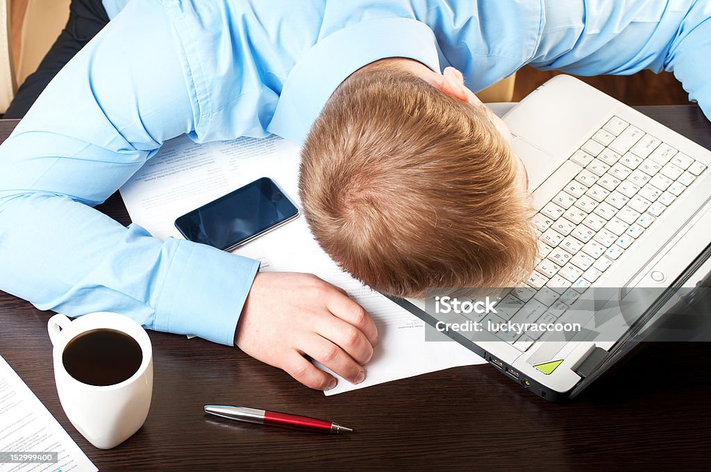 Young businessman sleeping on his table Adult Stock Photo