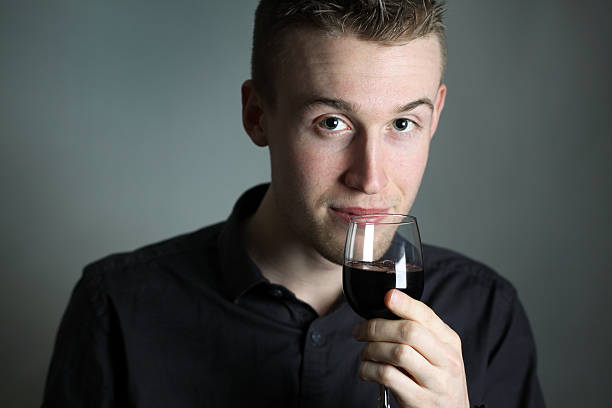 Young man enjoying a glass of red wine stock photo