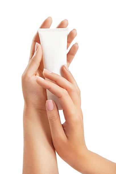 Woman's hands with hand care cream tube stock photo