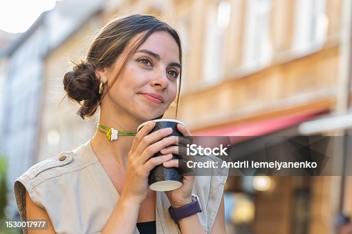 istock Young woman girl enjoying drinking morning coffee hot drink, relaxing, taking a break in city street 1530017977