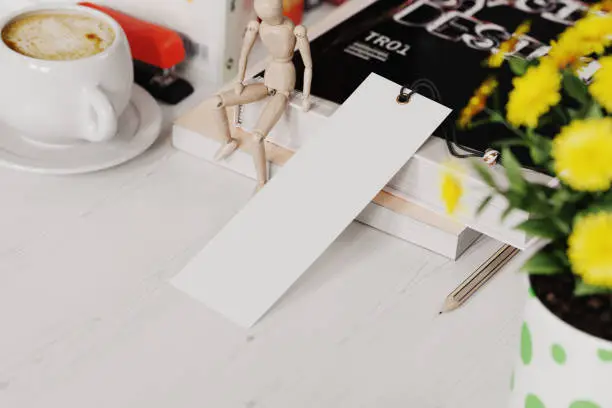 Photo of Paper bookmark at workplace mockup. 3D rendering