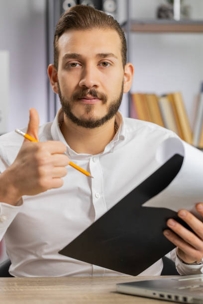 istock Business man reading business contract, planning project, analyzing resume, good paperwork results 1530038521