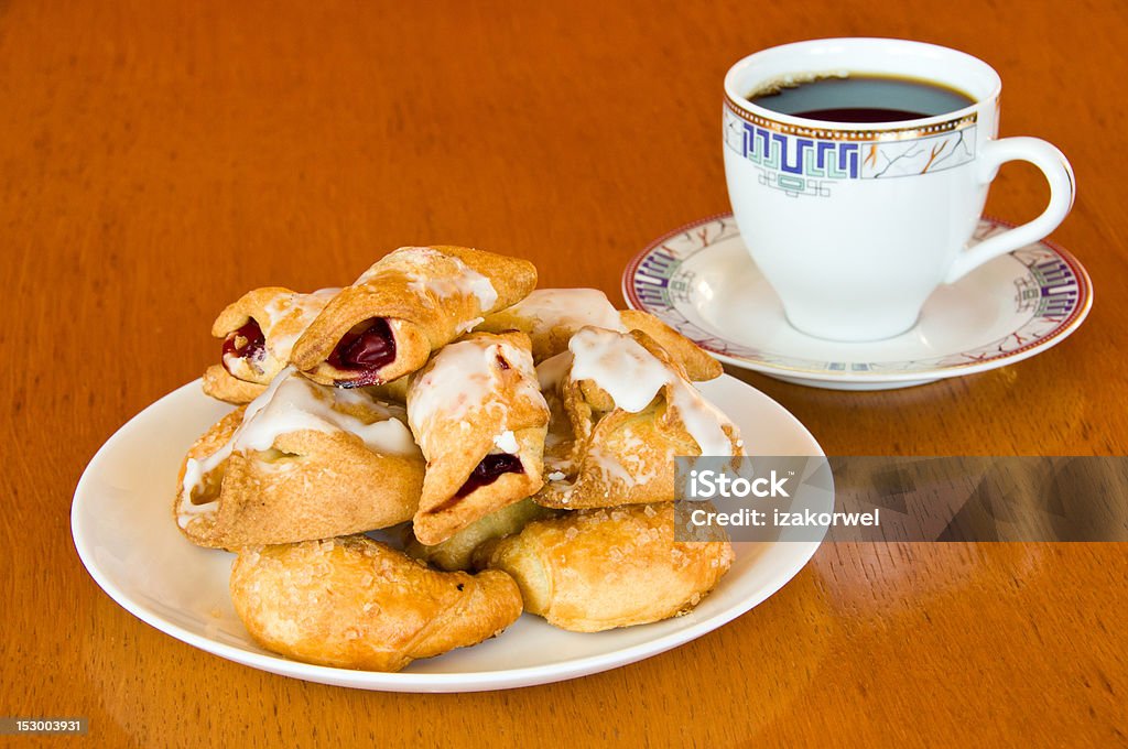 Pastry and a cup of coffee on wooden table Plate of fresh golden brown assorted pastry with a cup of aromatic coffee on old wooden table Baked Stock Photo