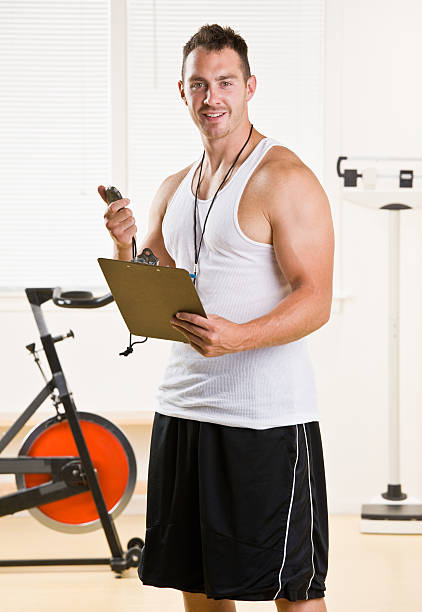 istock Personal trainer holding stop watch and clipboard 153004636