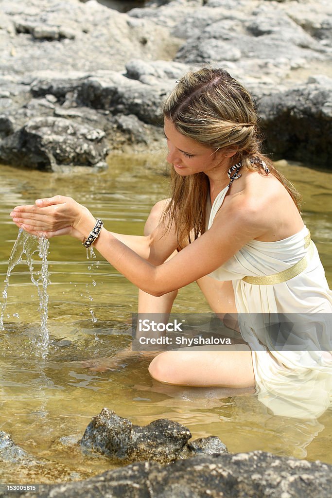 Atractiva Joven mujer sentada en el agua - Foto de stock de Accesorio personal libre de derechos