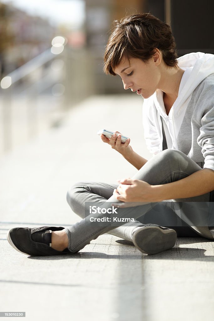 girl with cell-phone natural light , selective focus on eye, urban life concept Adult Stock Photo