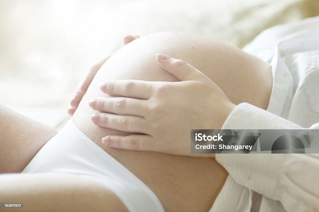 Беременная женщина держит ее - Стоковые фото Беременная роялти-фри