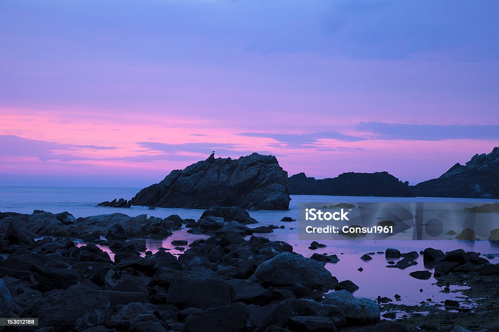 Dawn Dawn at Cap de Creus. The sun begins to peek over the horizon. Peninsula north of the Costa Brava which sits on geological levels of more than 450 million years and since 1984 is considered natural area protected within the category of natural park. Bay of Water Stock Photo