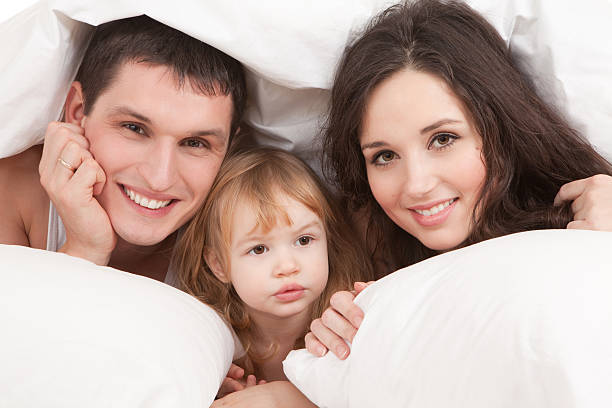 istock Happy family resting on the white bed 153013430