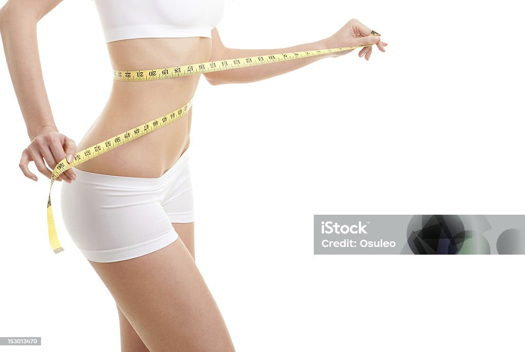 Athletic woman wrapping a tape measure around herself Athletic woman with measure tape Adult Stock Photo