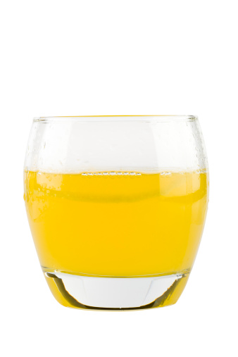 Yellow drink in lowball glass isolated on white background