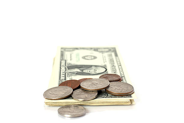 istock cents lying on pack of dollar banknotes 153014992