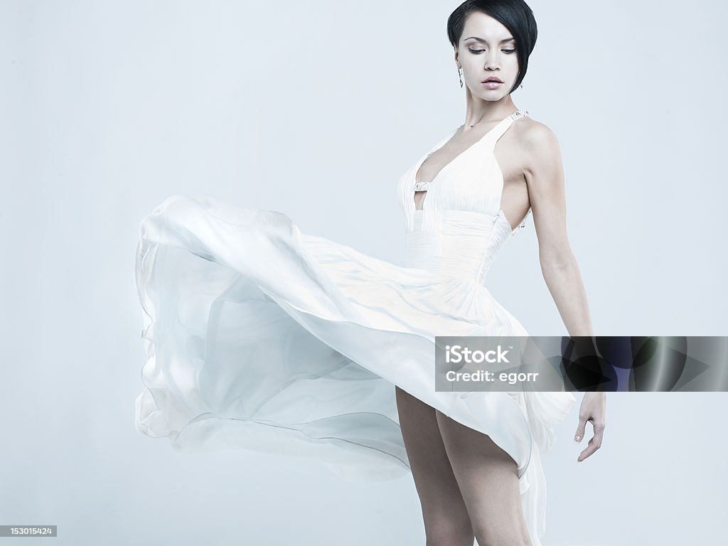 Beautiful young lady in a billowing white dress Fashionable photo of beautiful young lady in a billowing white dress Dress Stock Photo