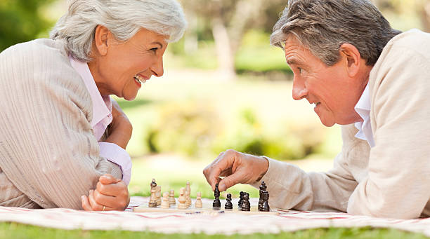 Elderly couple playing chess Elderly couple playing chess senior chess stock pictures, royalty-free photos & images