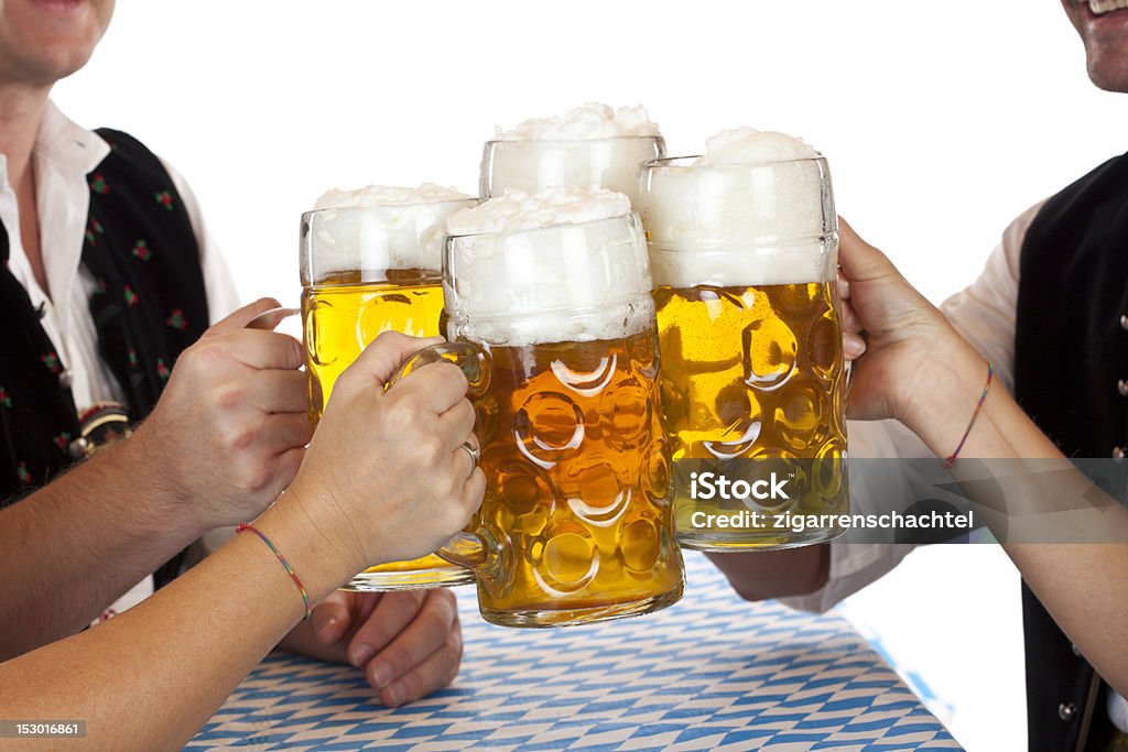 Bavarian men and women toast with Beer Fest beer stein Bavarian men and women toast with Beer Fest beer stein. Isolated on white background. Adult Stock Photo