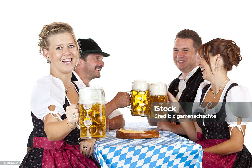 Bavarian homens e mulheres brinde com uma caneca de cerveja Oktoberfest - Foto de stock de Adulto royalty-free