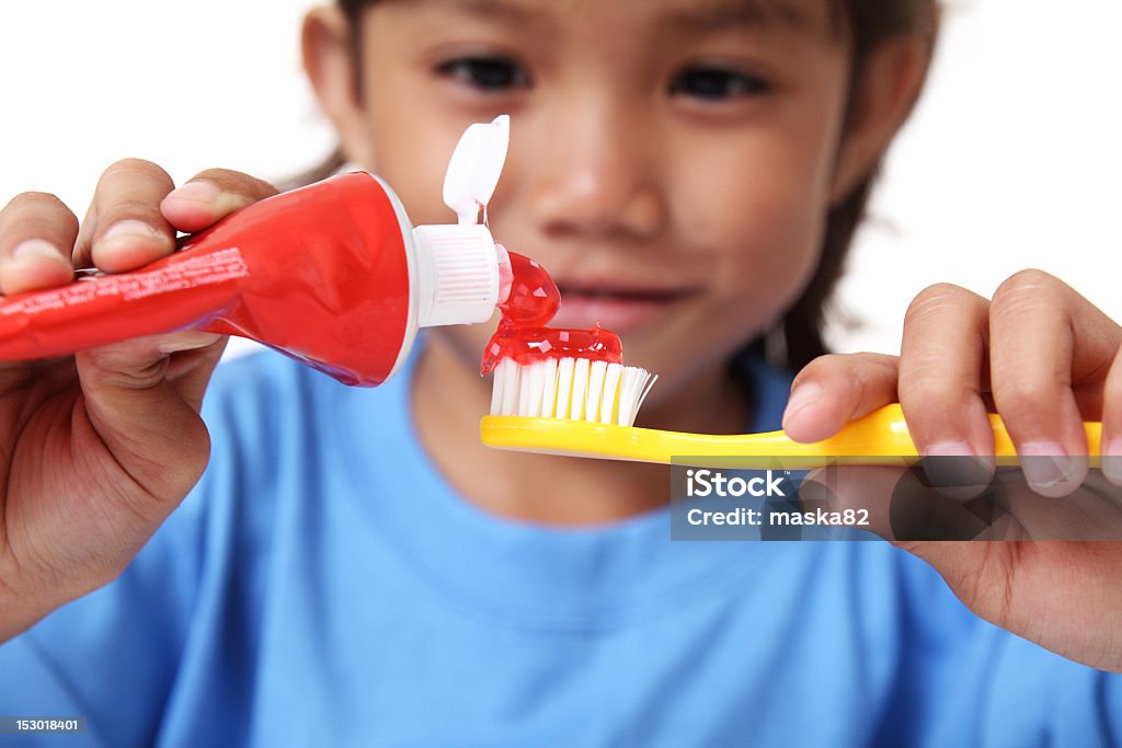 Tooth paste and Toothbrush Young girl squeezing tooth paste on a toothbrush Toothpaste Stock Photo