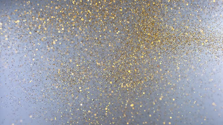 SLO MO LD Golden glitter falling against grey background