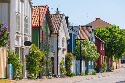 A street in in the city of Västervik, Sweden, with old wooden houses in different colors.