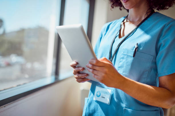 istock Close-up digital tablet held in nurse's hands beside window 1530244707