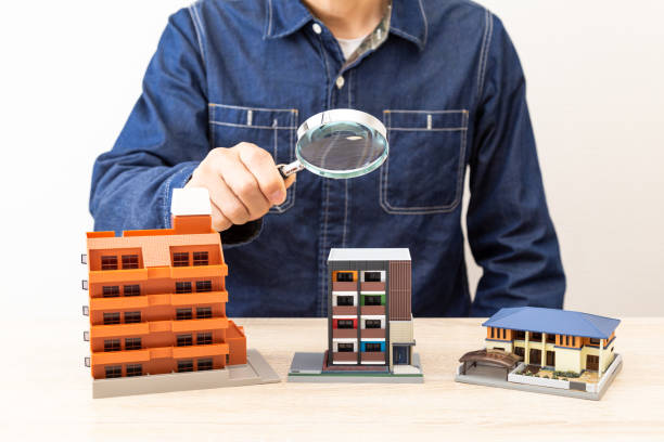istock Man observing a model of a house 1530250333