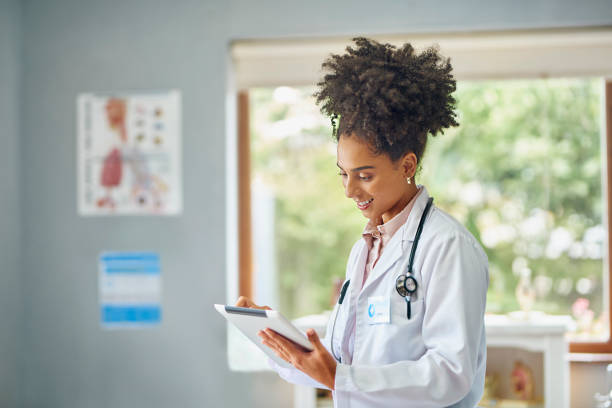 istock Cheerful female doctor using digital tablet in clinic 1530254265