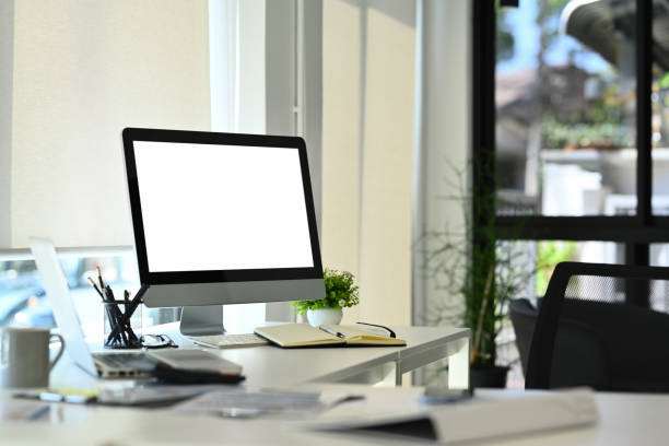 istock Blank screen computer, office supplies and potted plant on white table. Empty screen for your webpage or advertise text. 1530273412