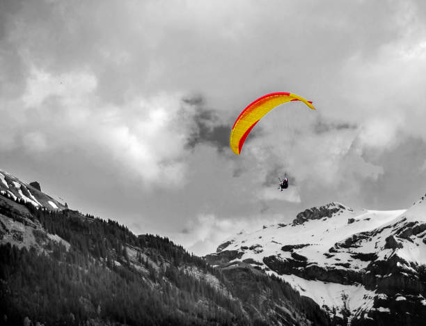 Paraglider in the mountains enjoying paragliding .