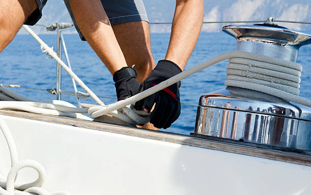 Operating Sail Winch on sailing boat Typical operation of attaching a rope on a sailboat interlace format stock pictures, royalty-free photos & images