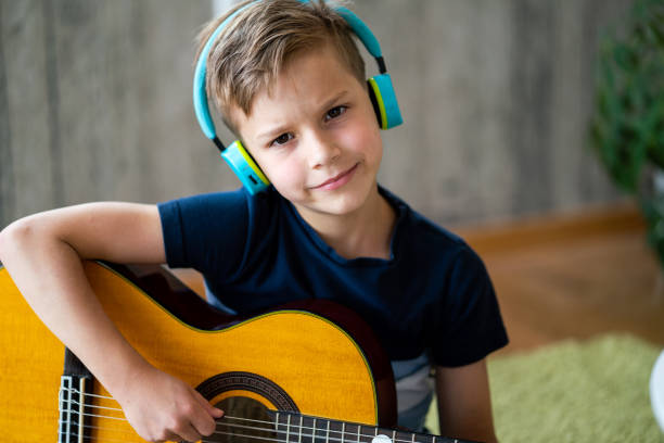 istock Boy playing acoustic guitar at home 1530319024