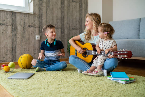 istock Woman playing guitar whit her son and daughter 1530339623