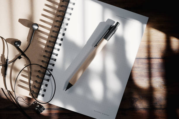 istock Kraft pen on the open notepad with headphones mockup. 3D rendering 1530347935